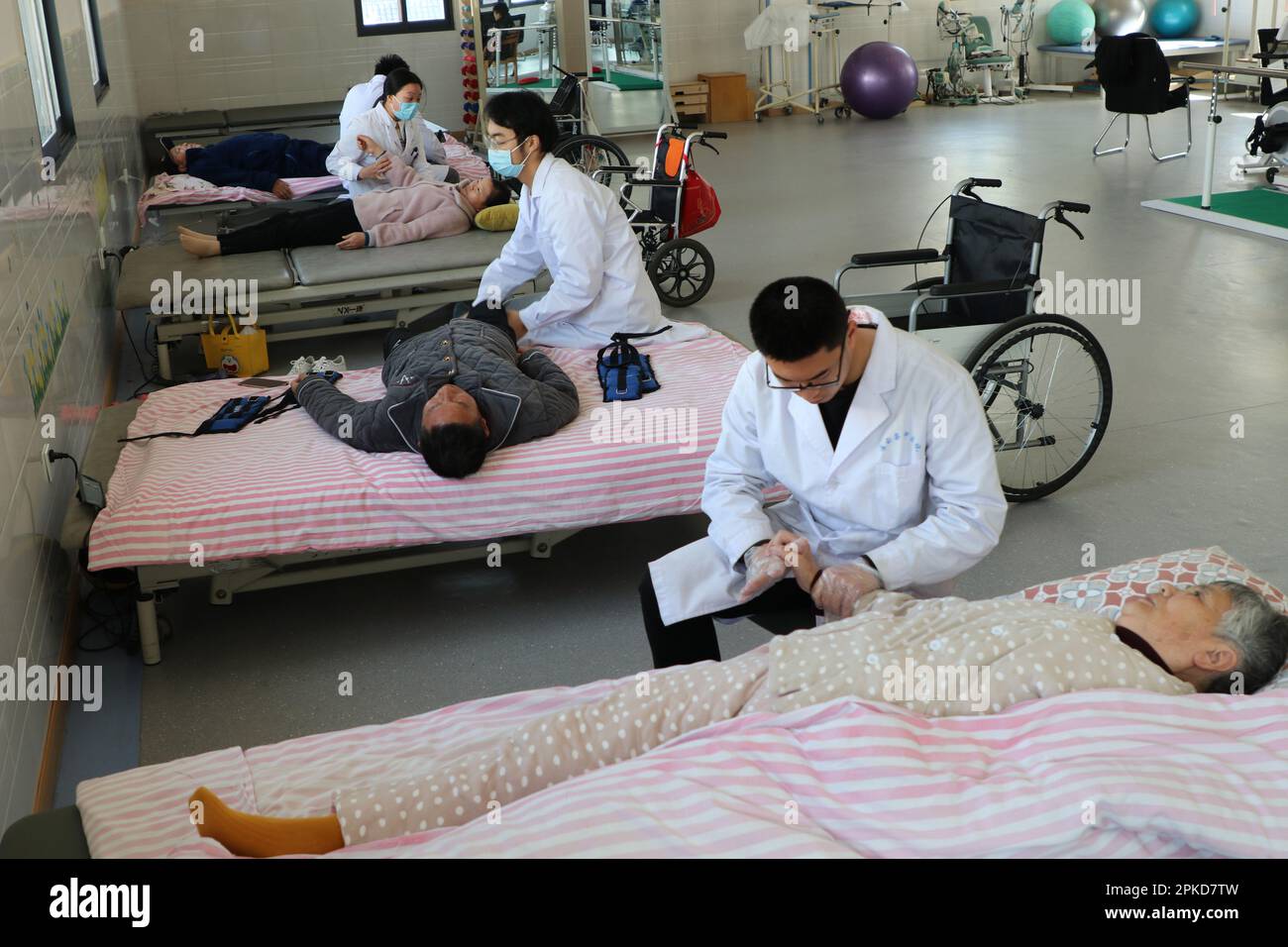 LIANYUNGANG, CINA - 7 APRILE 2023 - il personale medico effettua un trattamento di riabilitazione su un paziente presso il Luhe Community Health Center nella contea di Guanyun, Foto Stock