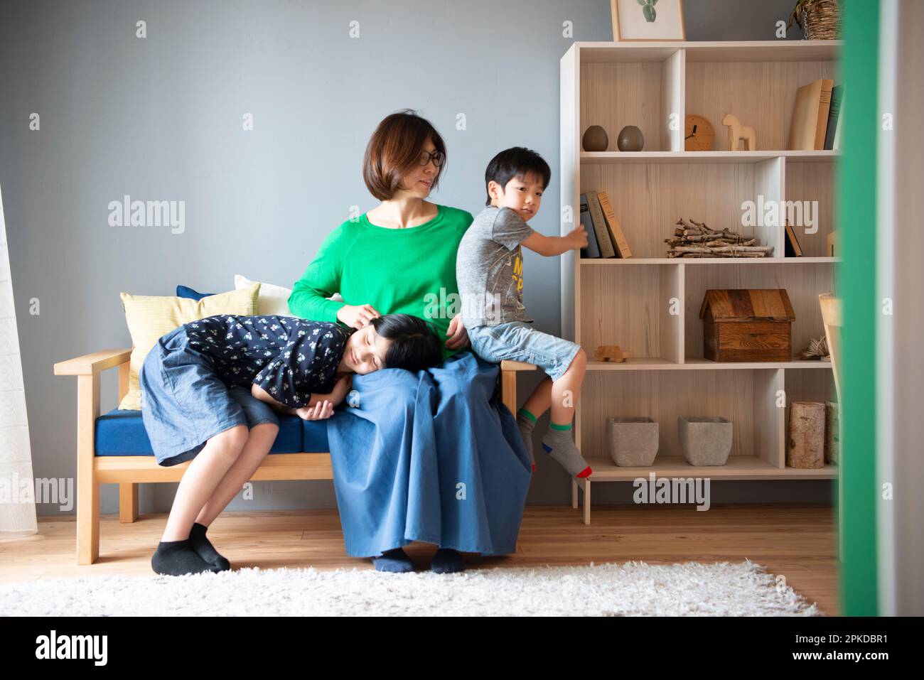 I genitori e i bambini si rilassano sul divano del soggiorno Foto Stock