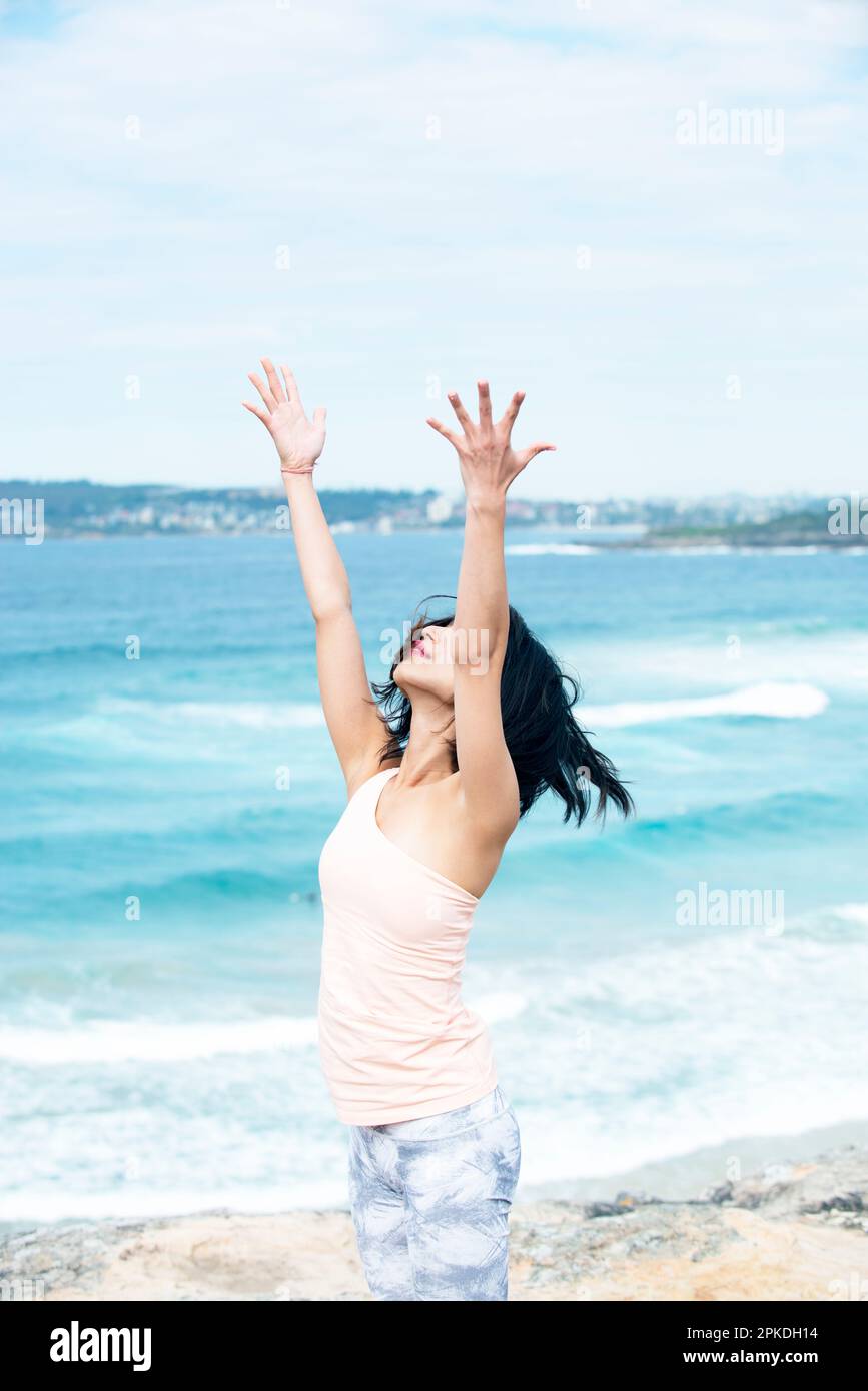 Donna che fa Yoga nel mare Foto Stock