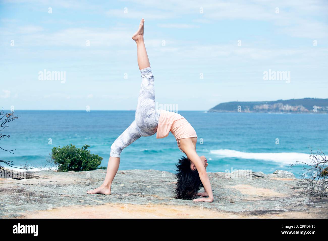 Donna che fa Yoga nel mare Foto Stock