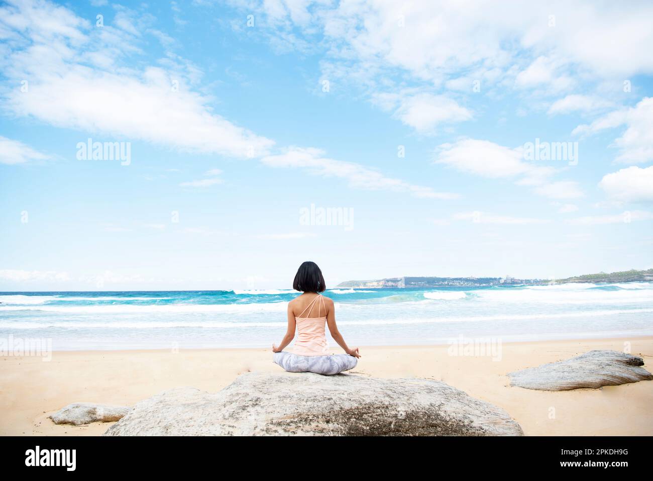 Donna fare yoga sulla spiaggia Foto Stock