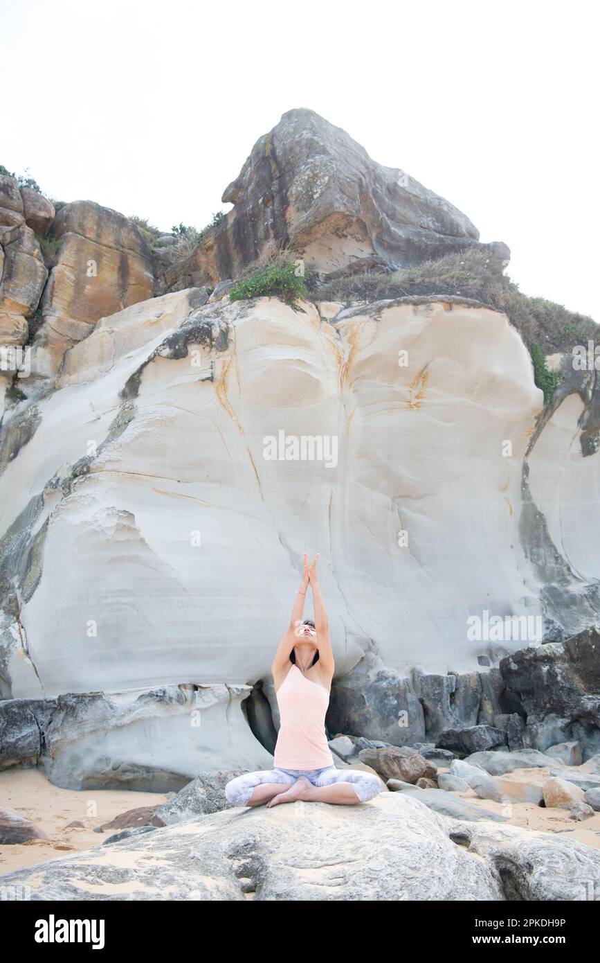 Donna fare yoga sulla spiaggia Foto Stock