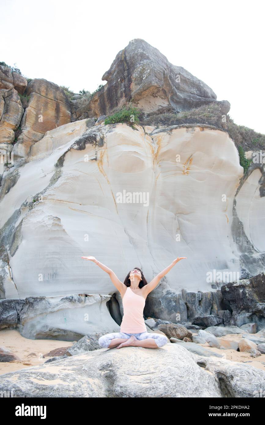Donna fare yoga sulla spiaggia Foto Stock