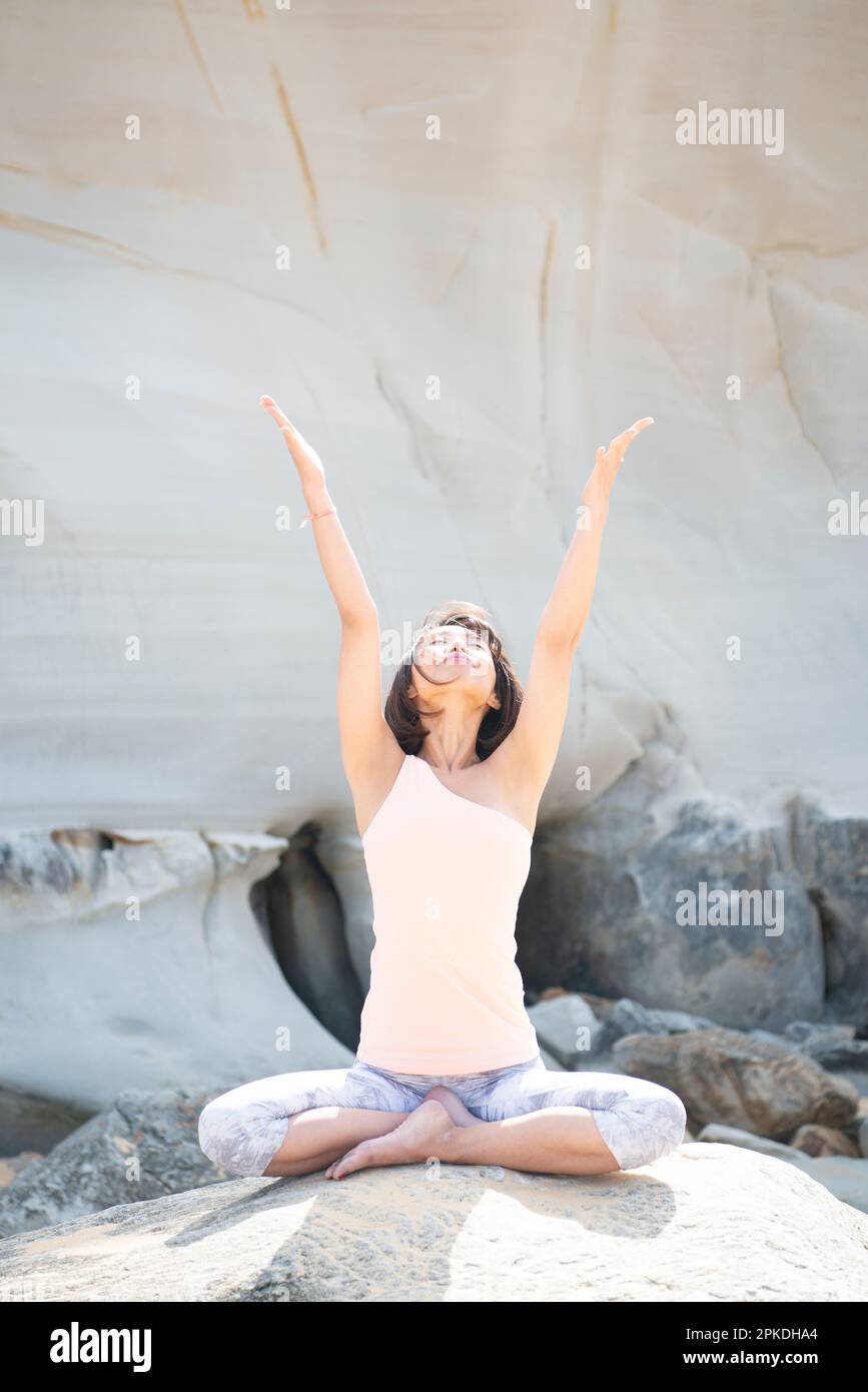Donna fare yoga sulla spiaggia Foto Stock