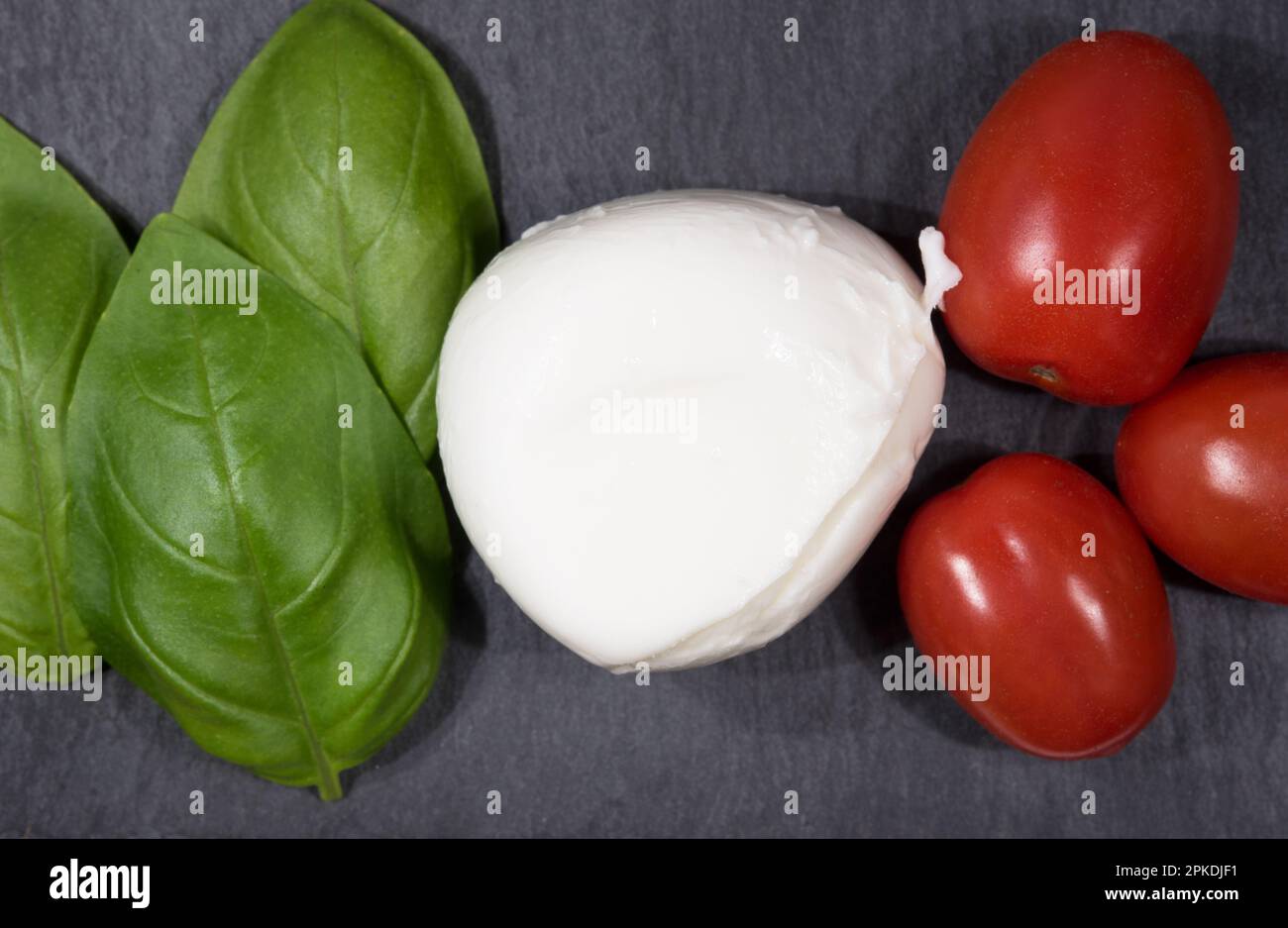 una bella mozzarella di bufala con basilico e pomodorini, la ricetta della caprese Foto Stock