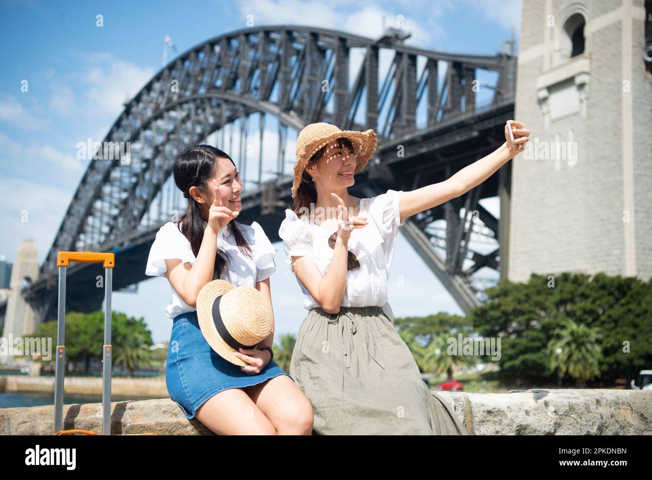 2 donne che prendono selfie con ponte sullo sfondo Foto Stock