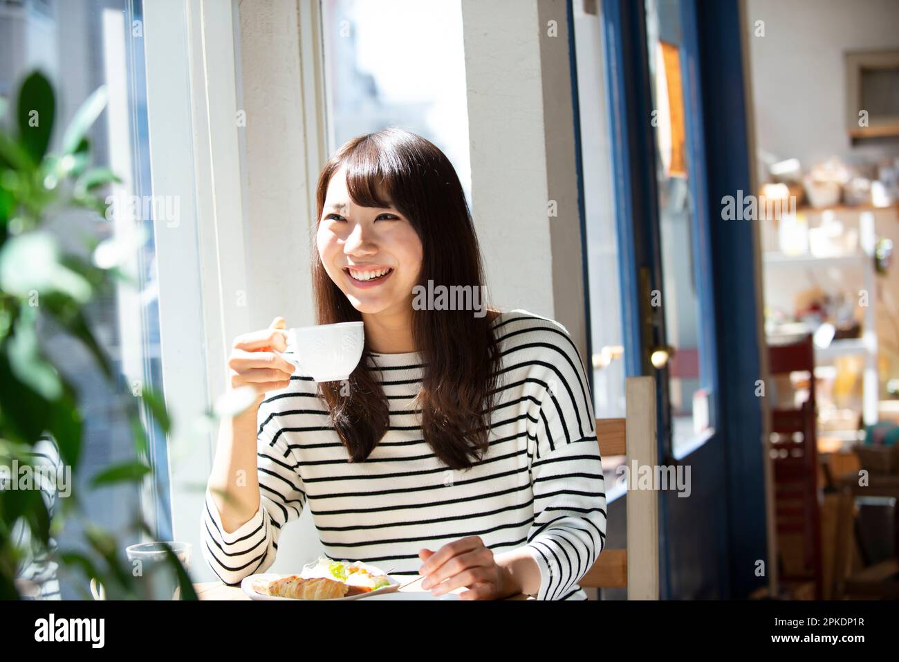 Donna che tiene una tazza di caffè in un caffè Foto Stock