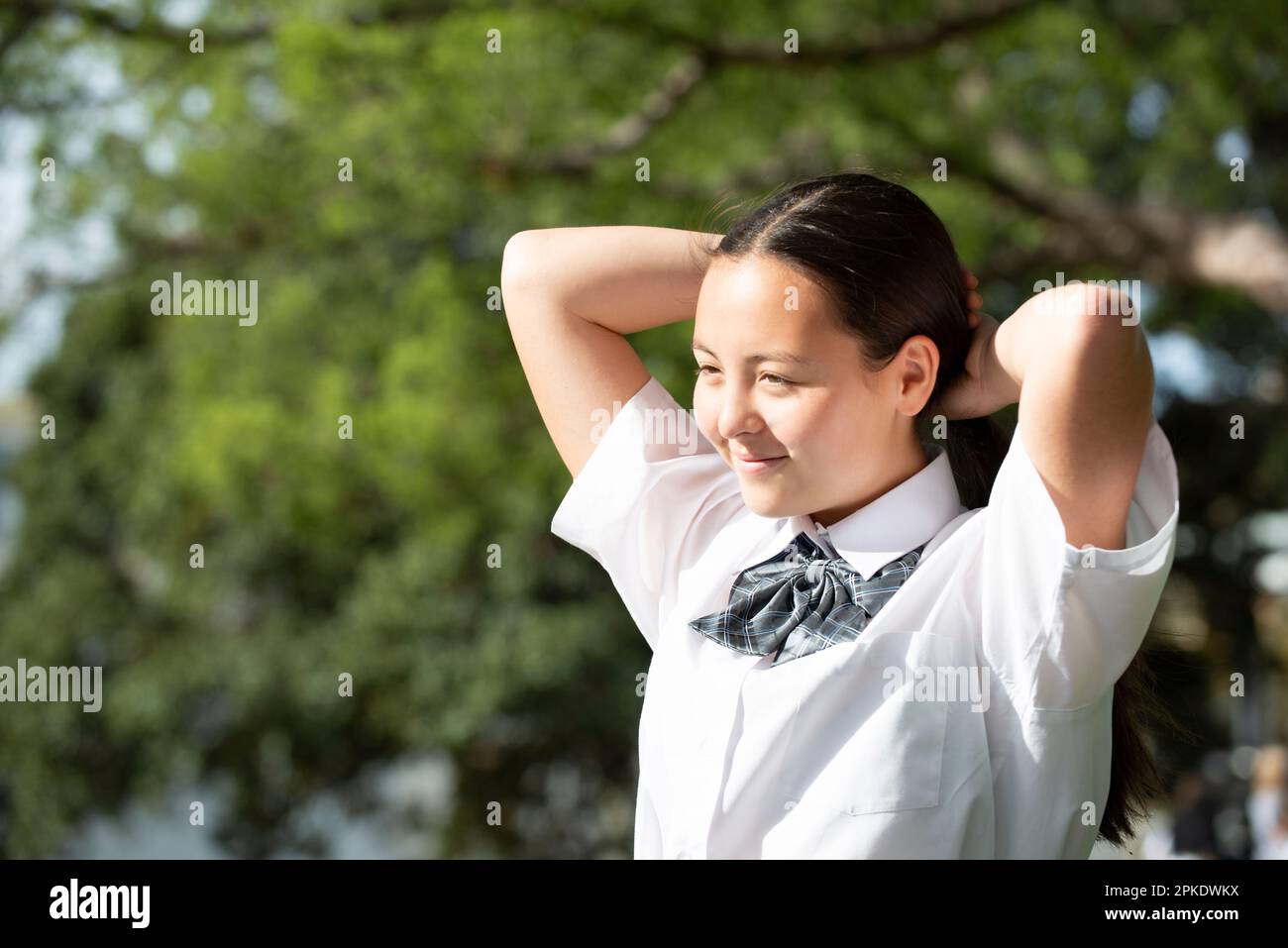 Studentessa in uniforme scolastica con i capelli legati Foto Stock