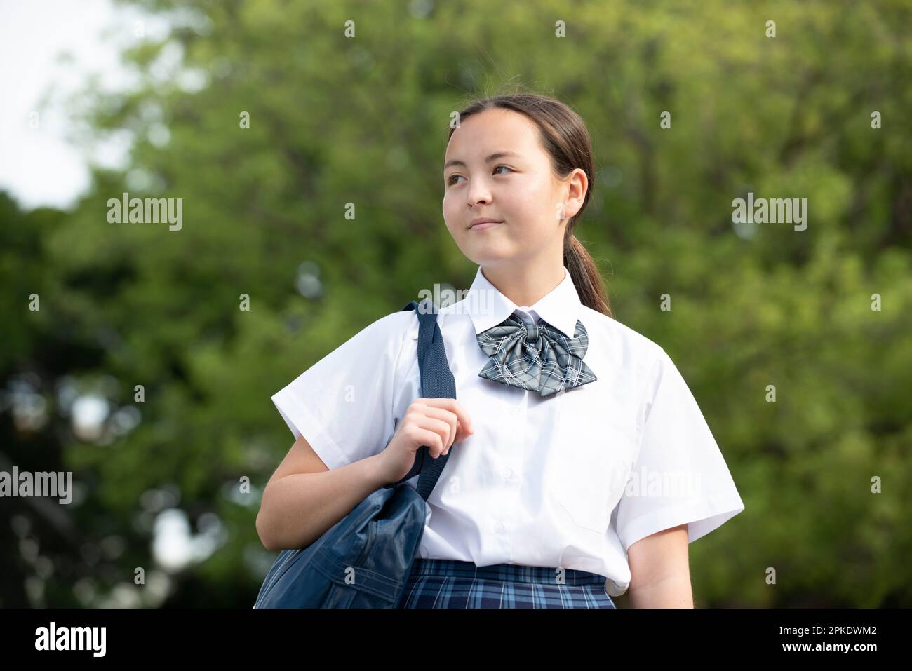 Studentessa in uniforme scolastica guardando in lontananza Foto Stock