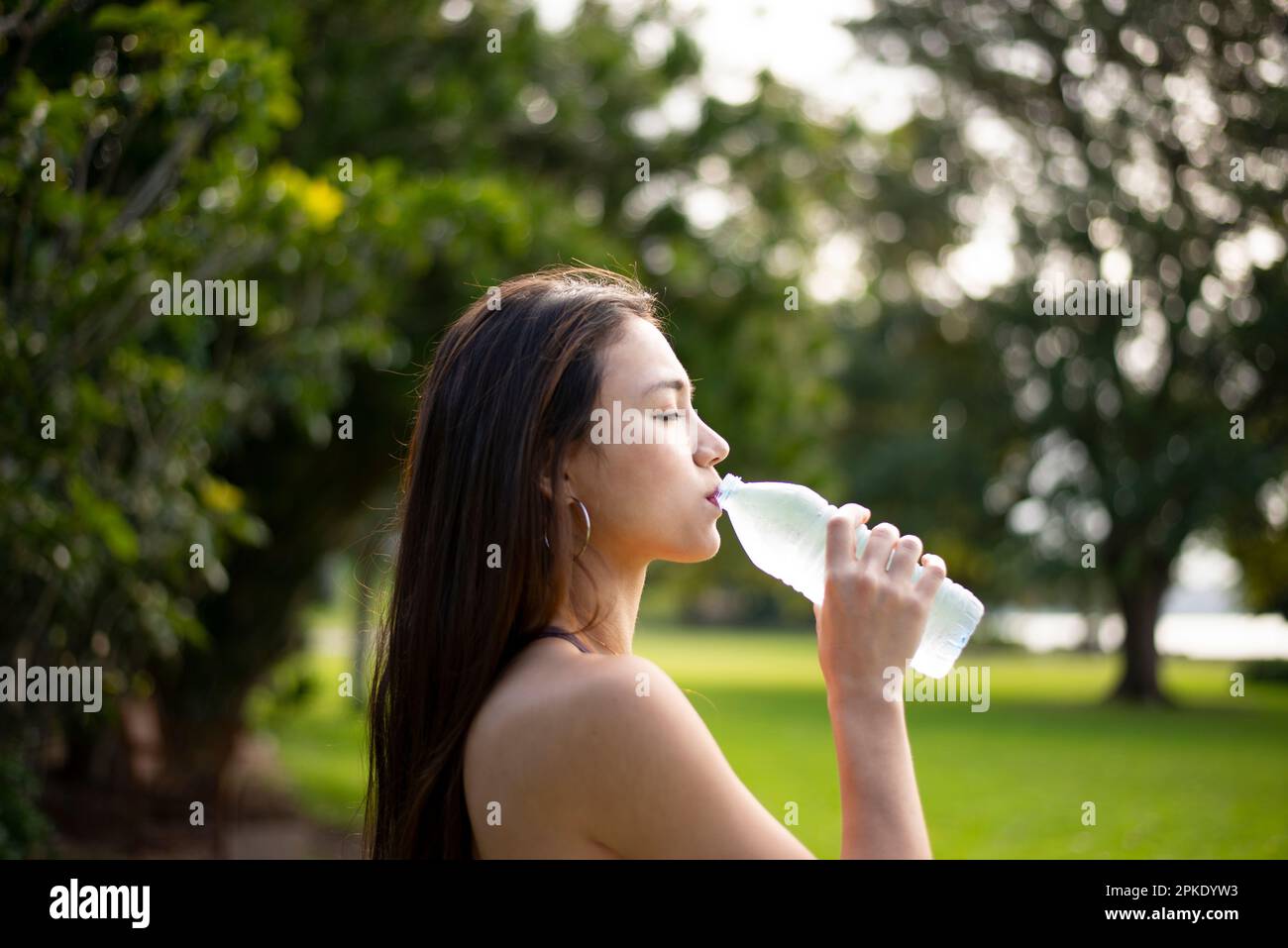 Donna di bere acqua da una bottiglia Foto Stock