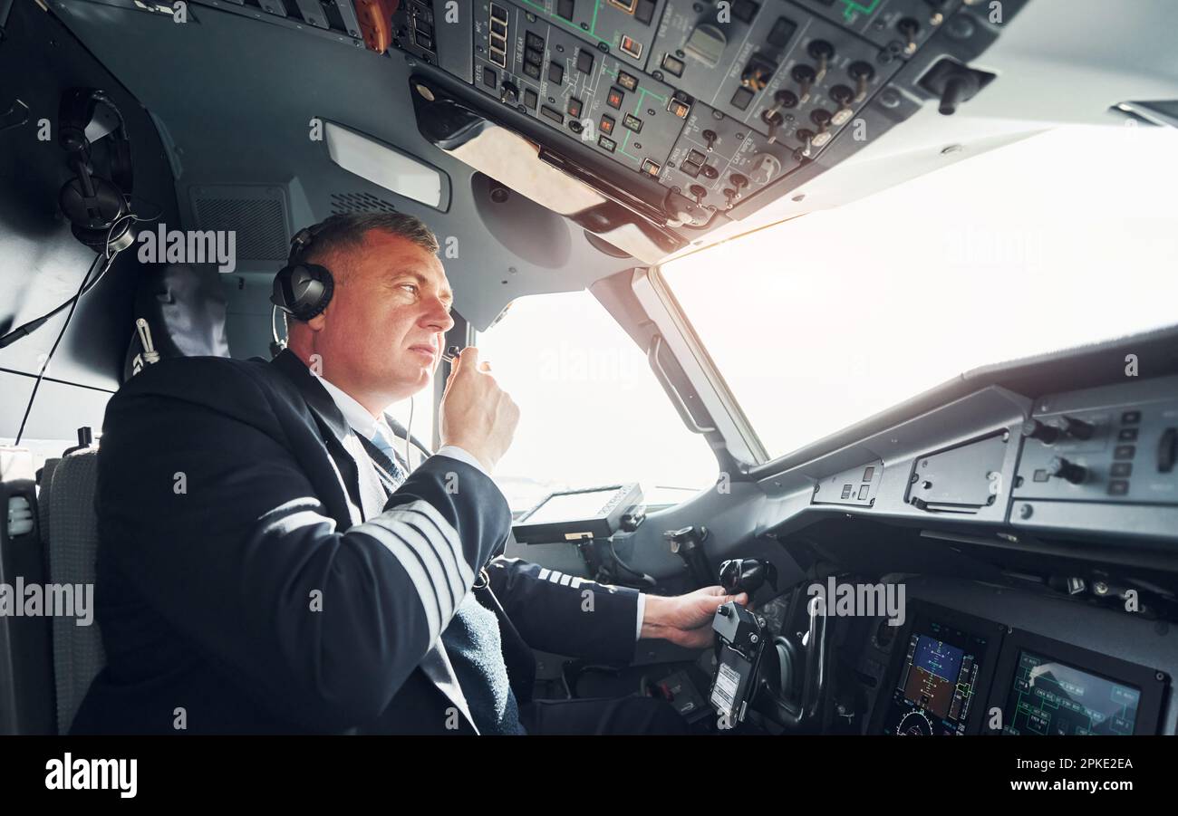 Vista laterale. Un pilota professionista è nel cockpit. Concezione del lavoro. Foto Stock