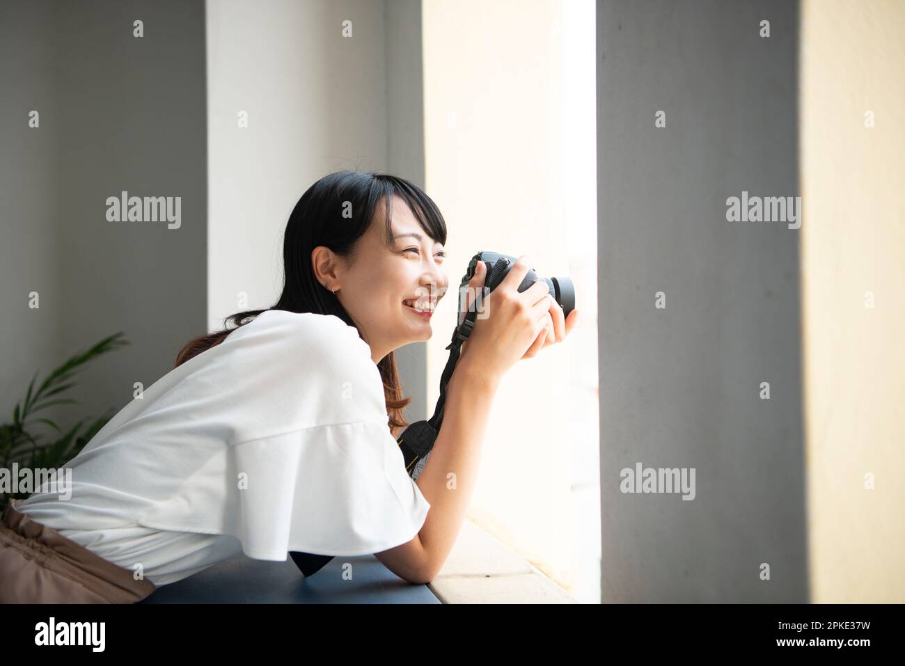 Donna che tiene una fotocamera reflex e sorridente Foto Stock