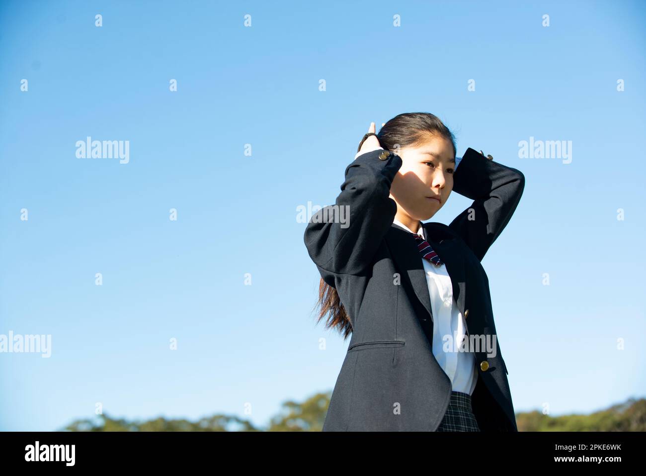 Studentessa in uniforme scolastica con i capelli legati Foto Stock