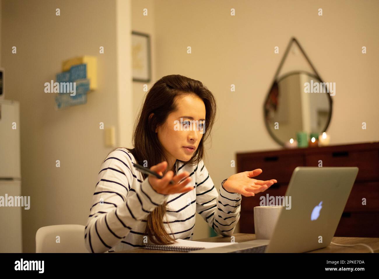 Una donna che partecipa a una riunione remota da casa Foto Stock