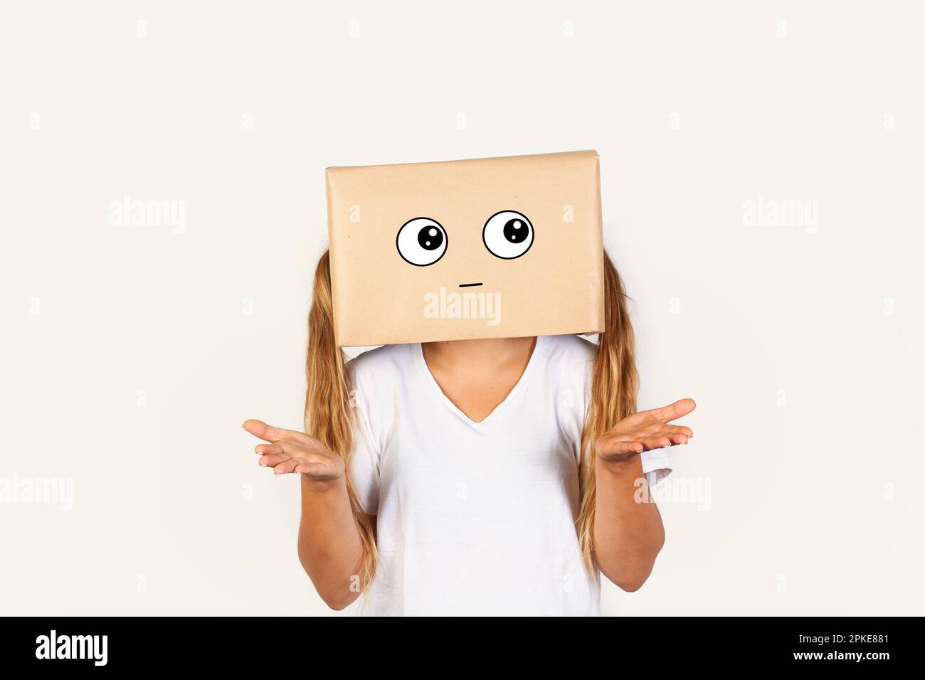 Donna con la testa in una scatola e non capendo gesto in piedi su uno sfondo bianco con spazio copia Foto Stock
