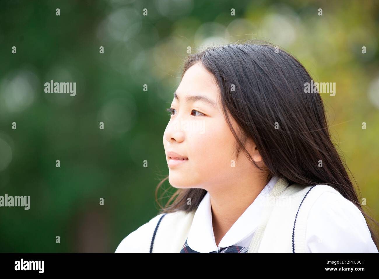 Studentessa in uniforme che guarda la distanza nel profilo Foto Stock