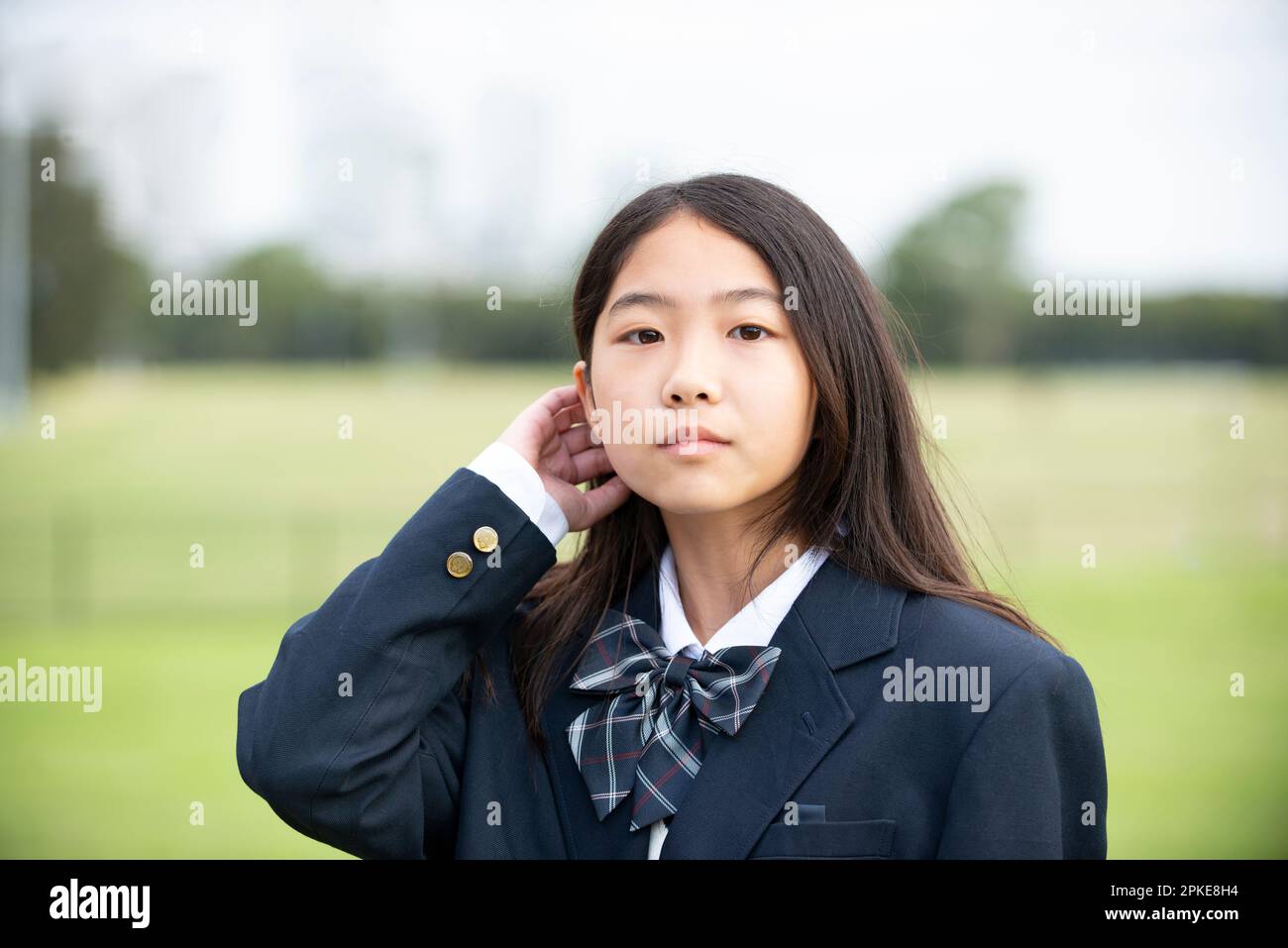 Studentessa in divisa scolastica che guarda a noi Foto Stock