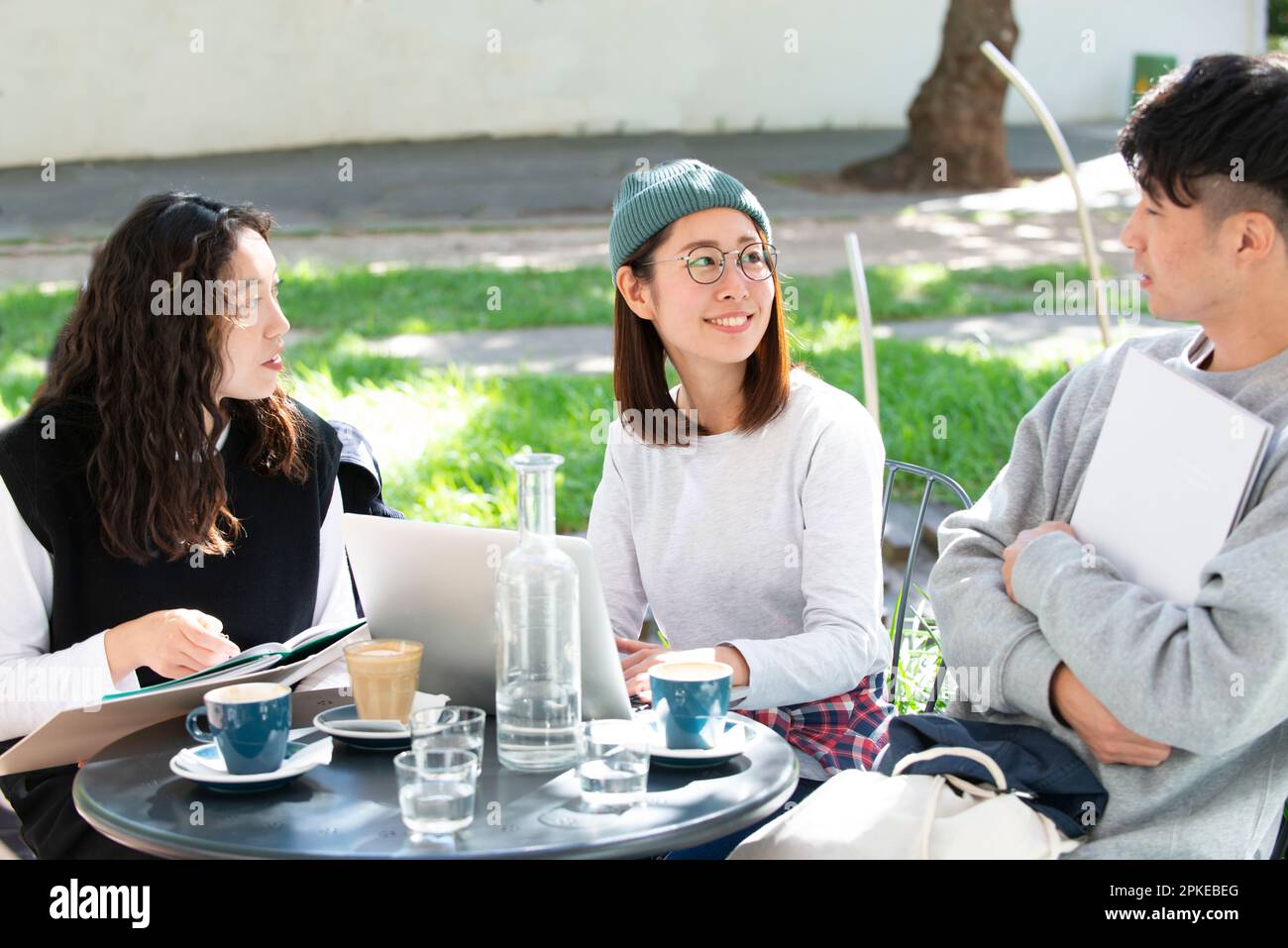 Tre studenti che studiano in un bar Foto Stock