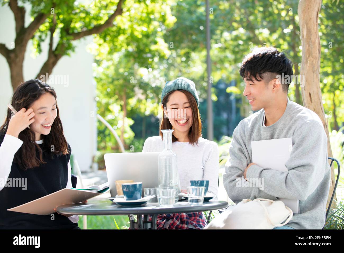 Tre studenti che studiano al bar Foto Stock