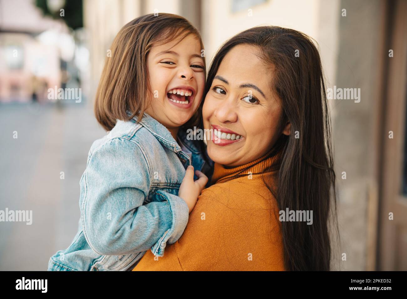 Felice madre del sud-est asiatico con sua figlia che si diverte nel centro della città - bella famiglia all'aperto Foto Stock