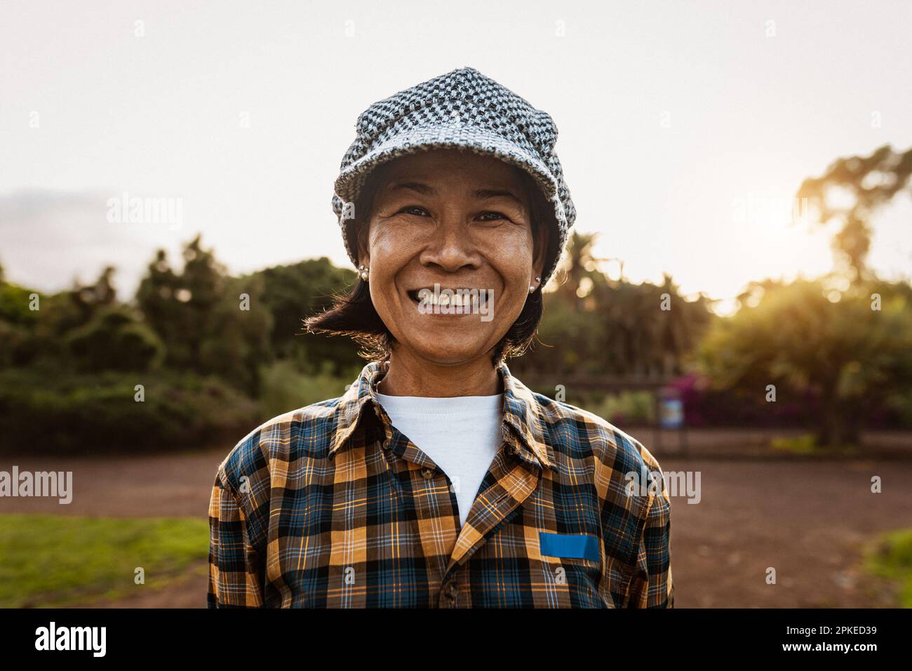 Felice sudest asiatico donna che si divertono sorridendo con la macchina fotografica in un parco pubblico Foto Stock