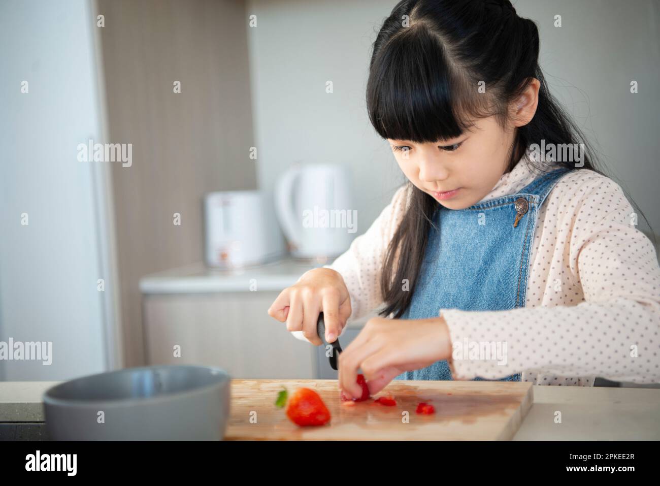 Ragazza che aiuta in cucina Foto Stock