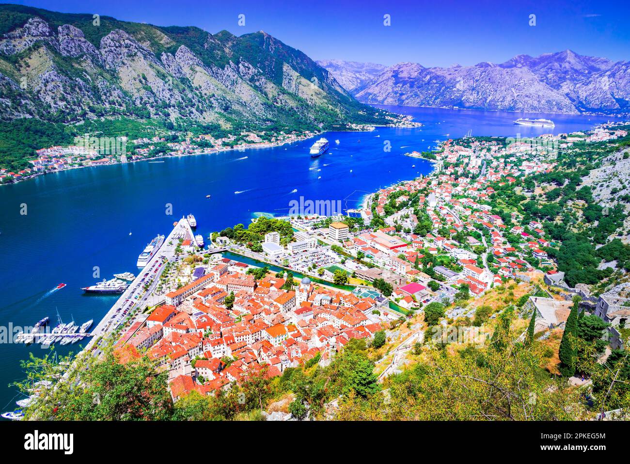 Kotor, Montenegro. Montagne imponenti panoramiche, baia scintillante, città medievale fortificata con tetti in terracotta, chiese storiche e strette strade acciottolate. Foto Stock