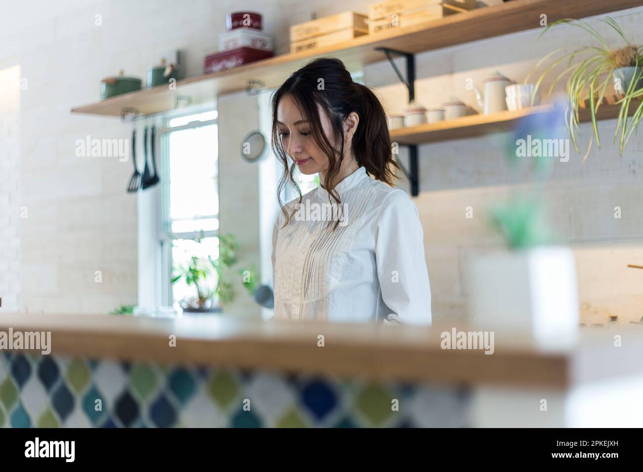 Donna che fa il lavoro di casa in cucina Foto Stock