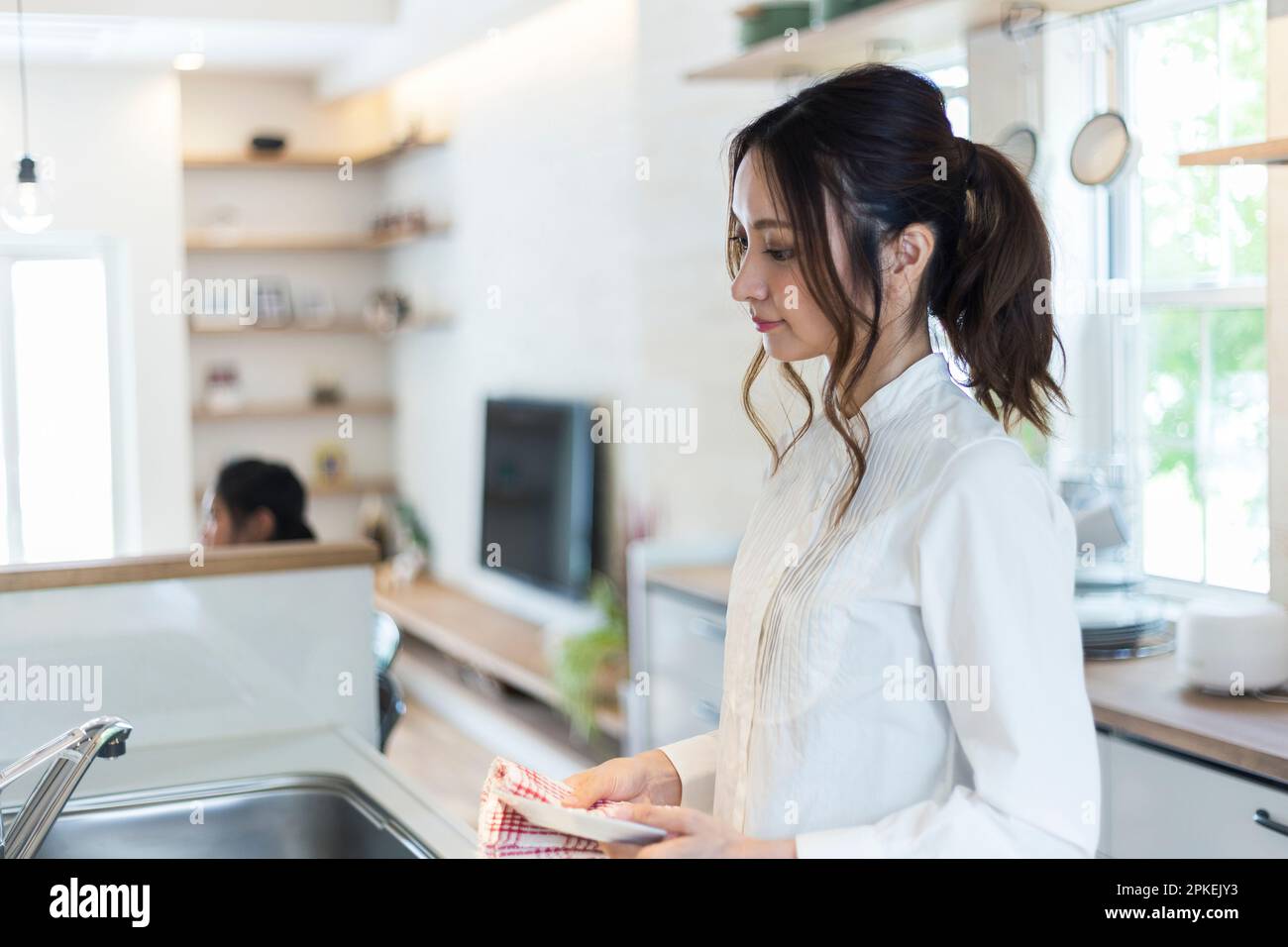 Donna che fa faccende in cucina Foto Stock