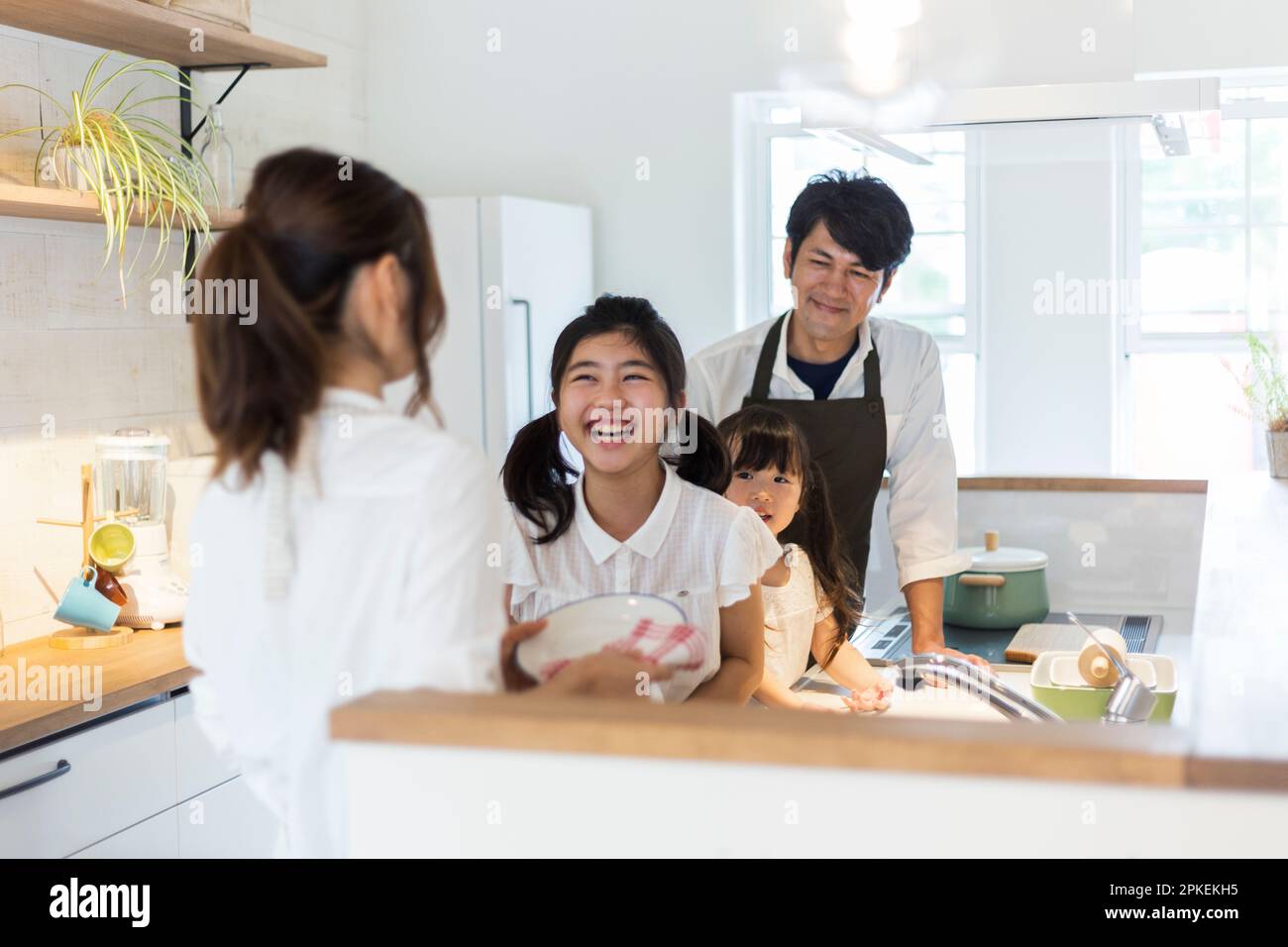 Famiglia di quattro persone in piedi in cucina Foto Stock