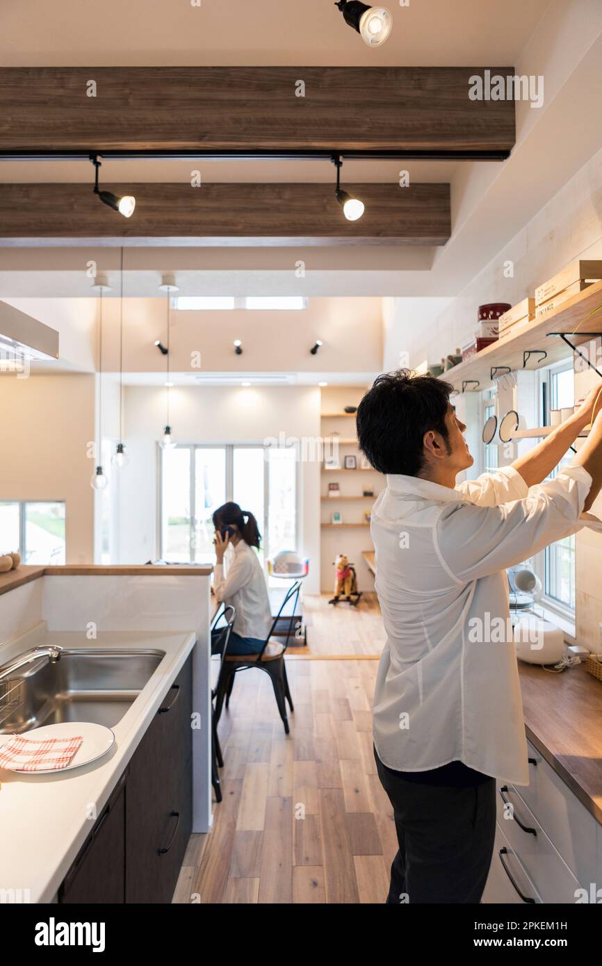 Donna che fa il lavoro di casa con l'uomo Foto Stock