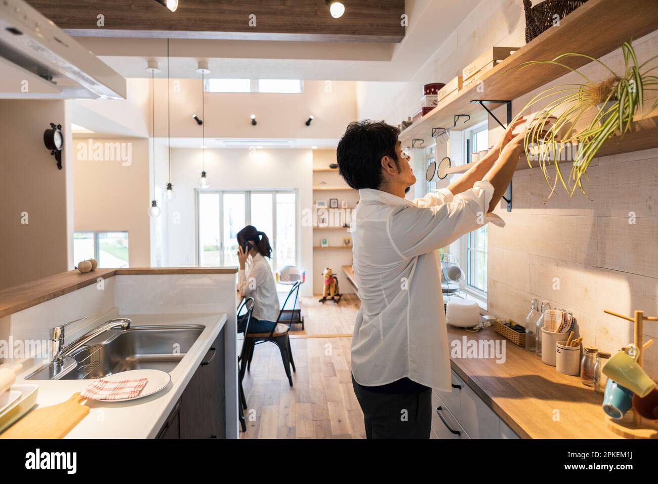 Uomo che fa lavoro di casa e donna al lavoro Foto Stock