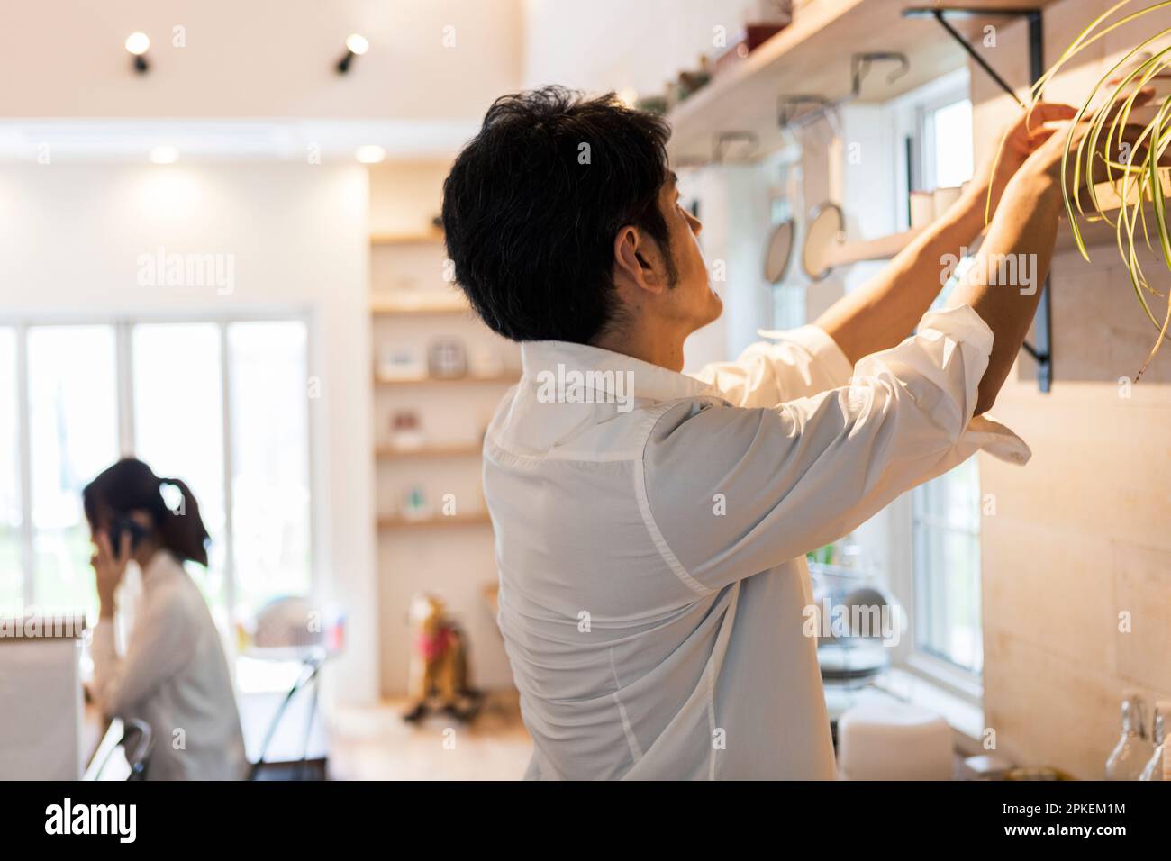 Donna che lavora con l'uomo che fa il lavoro di casa Foto Stock