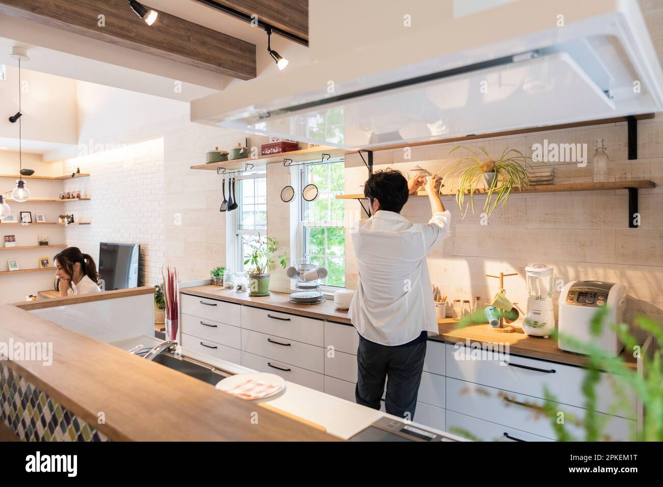 Donna che lavora con l'uomo che fa il lavoro di casa Foto Stock