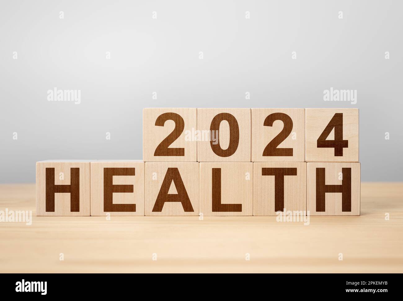 2024 concetto di salute. cubo di legno cambiare anno 2023 a 2024. sfondo grigio, spazio di copia. 2024 concetto di salute. cambio cubo di legno sulla scrivania Foto Stock