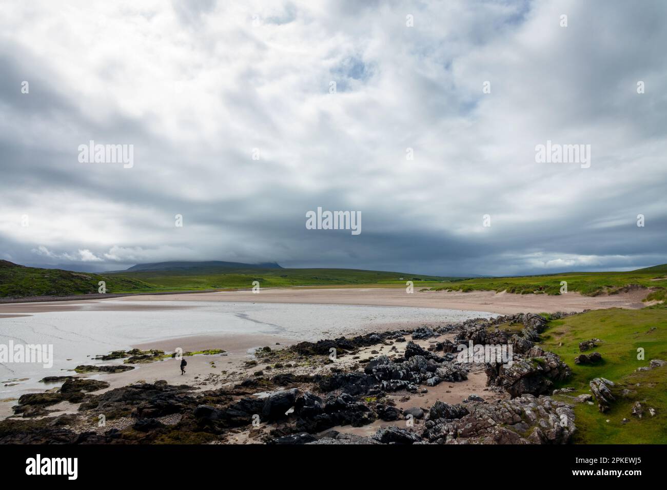 Lone uomo su una spiaggia sulla penisola di Coigach nel nord di Highlands, Scozia, Regno Unito Foto Stock