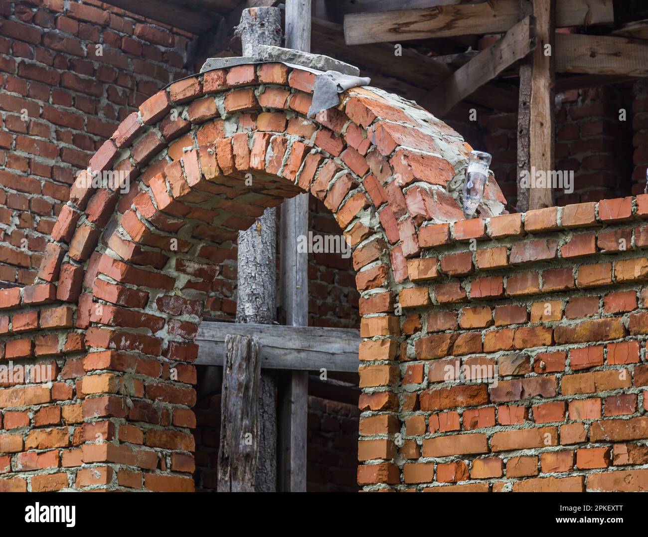 costruzione di un campanile e di una chiesa. Muro di mattoni. Ponteggi in legno Foto Stock