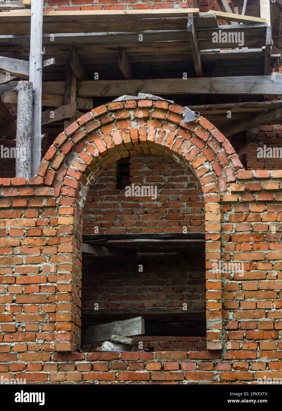 costruzione di un campanile e di una chiesa. Muro di mattoni. Ponteggi in legno Foto Stock