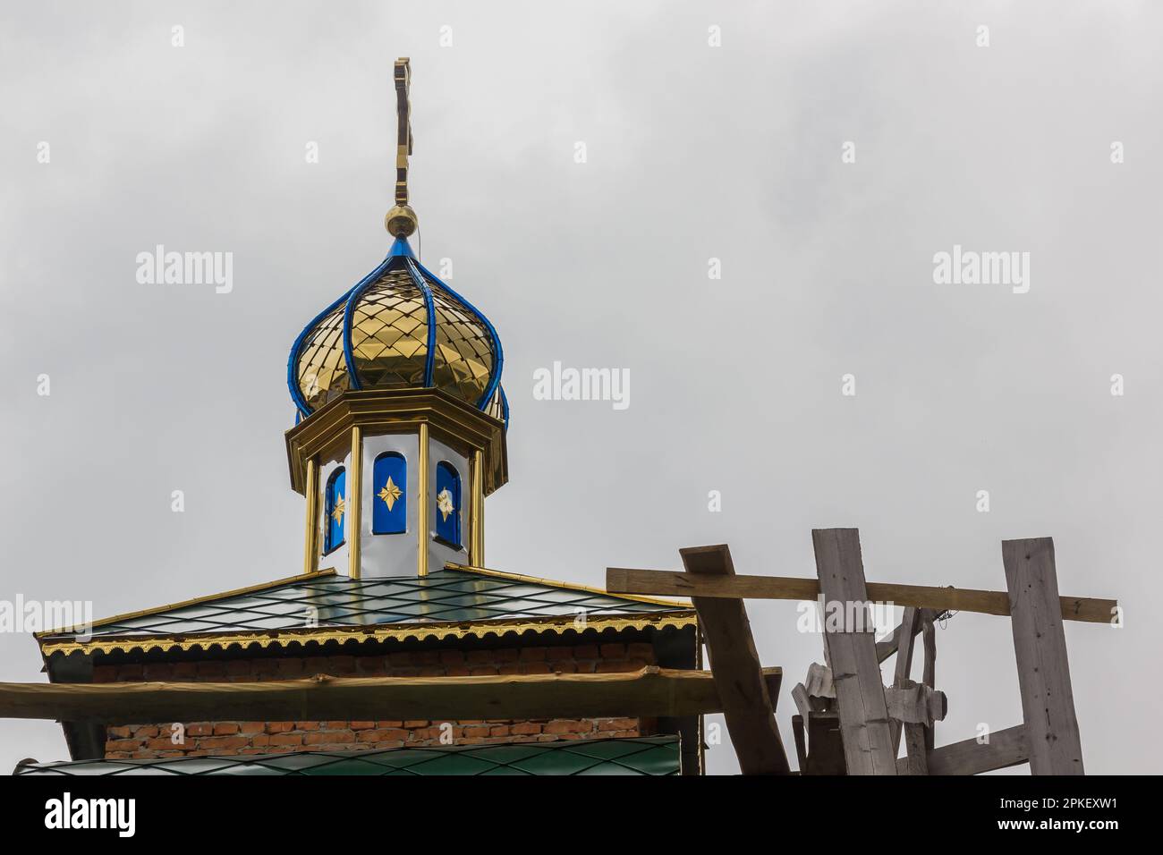 costruzione di un campanile e di una chiesa. Muro di mattoni. Ponteggi in legno Foto Stock