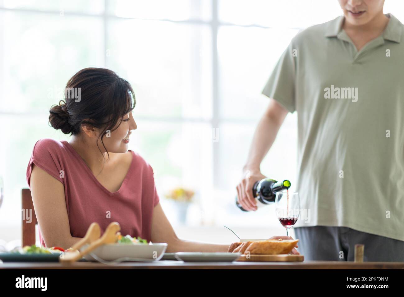 Donna che ha versato il vino Foto Stock