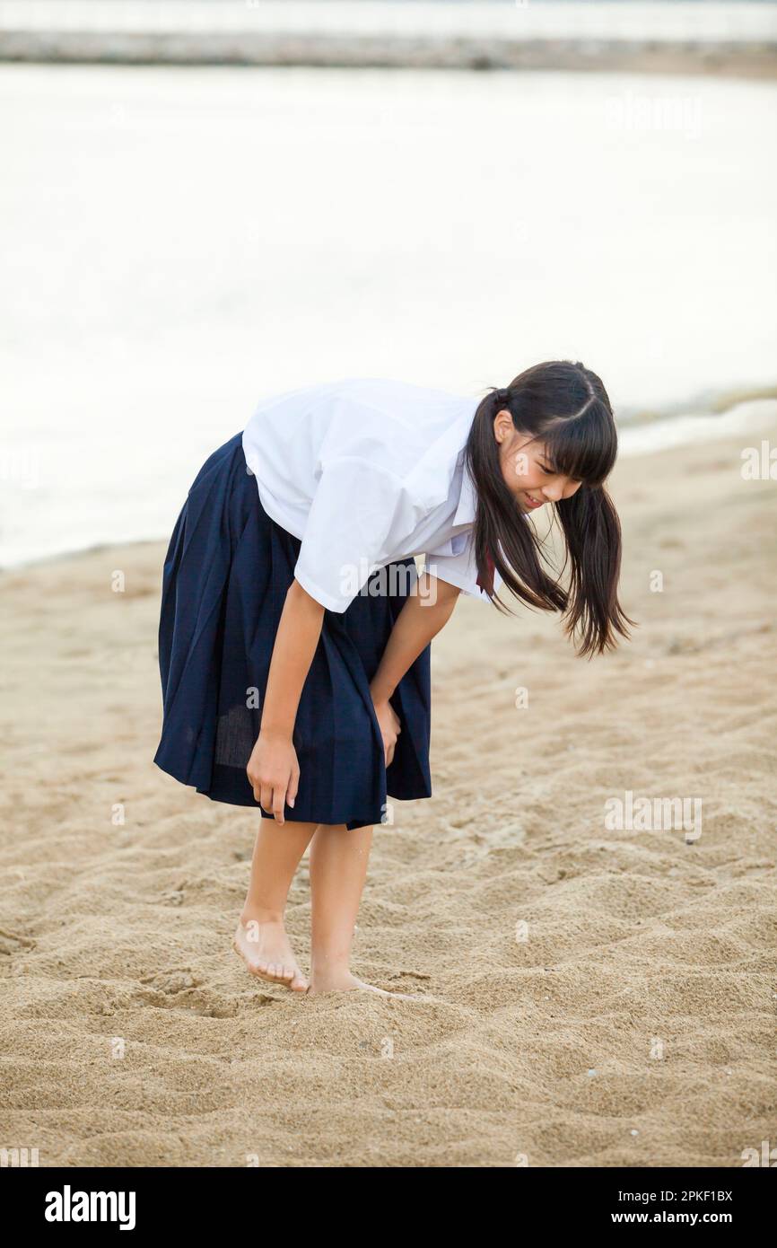 Studenti delle scuole superiori in cerca di qualcosa sulla spiaggia Foto Stock