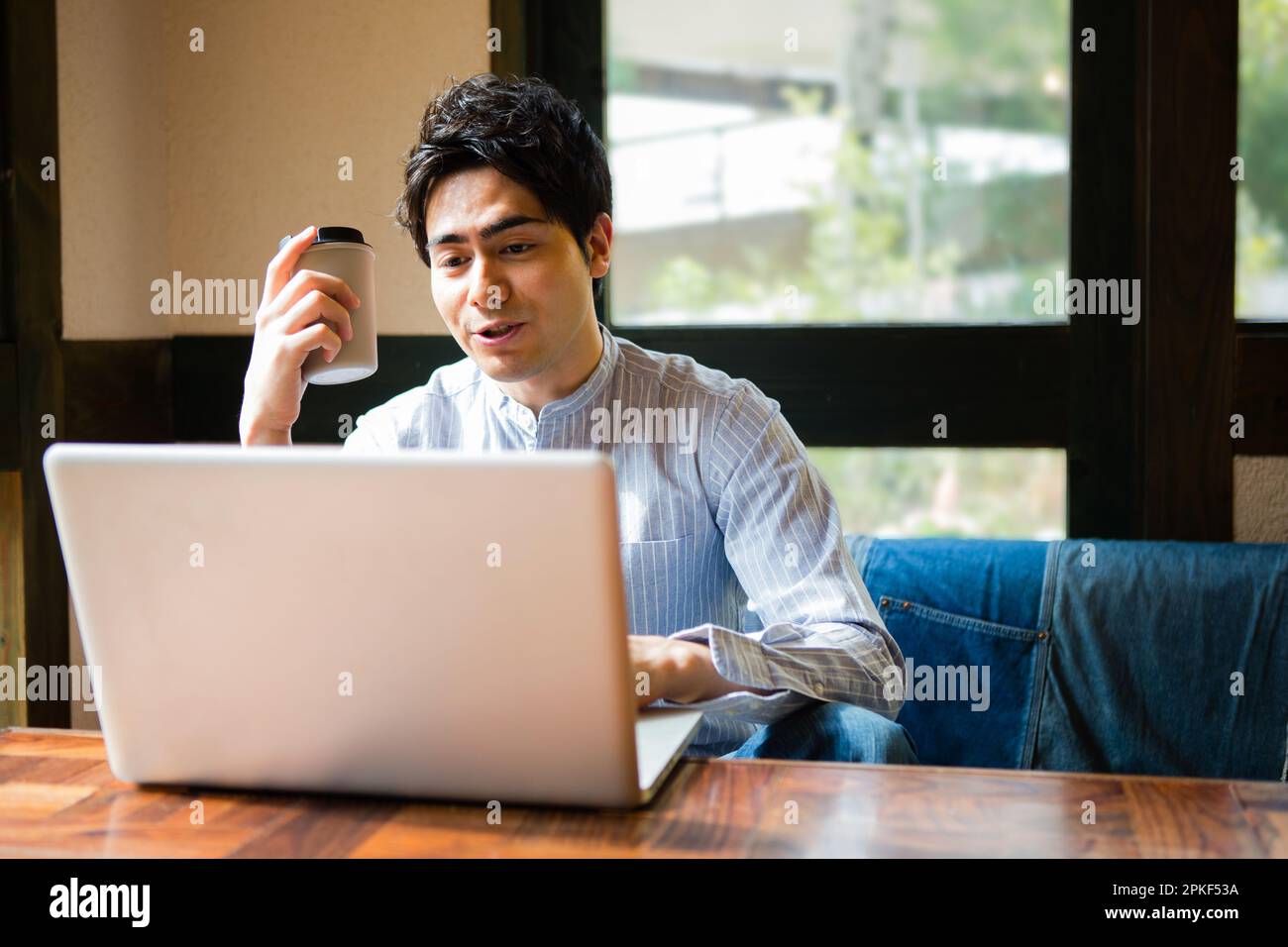 Uomini che usano i computer in un bar Foto Stock