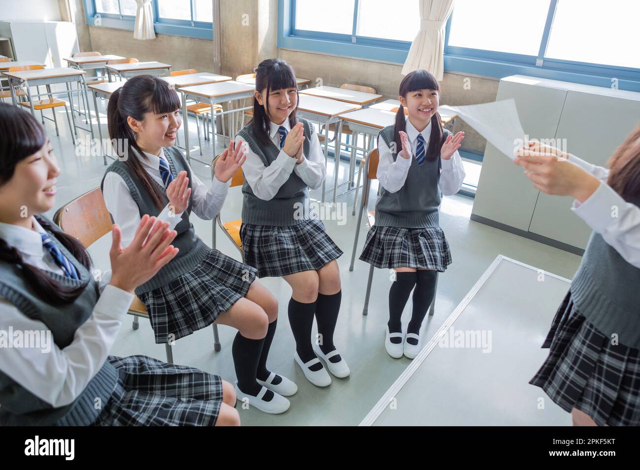 Le ragazze della scuola superiore junior leggono un manoscritto al podio Foto Stock