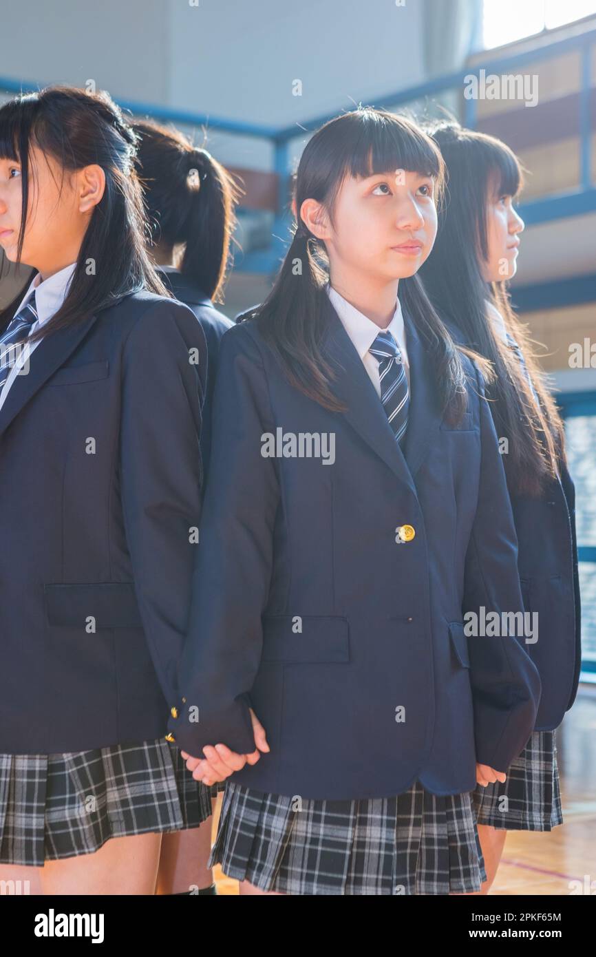 Ragazze della scuola superiore giovani in piedi in una fila nella palestra Foto Stock