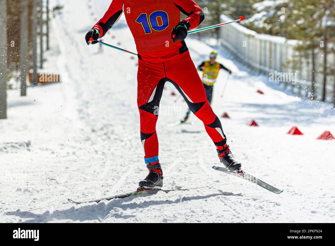 atleta maschile sciatore che corre in salita allo stadio di sci, gara di sport invernali Foto Stock