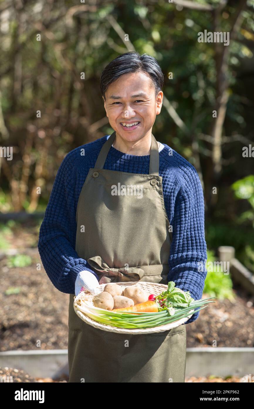 Uomo che tiene verdure dal campo Foto Stock