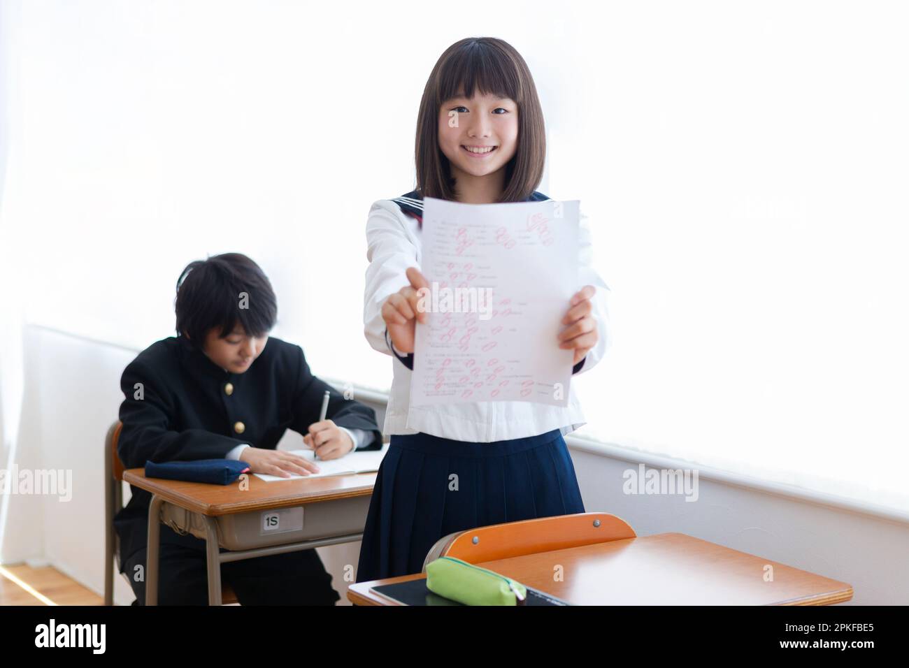 Studente di scuola superiore junior che tiene un test con un punteggio perfetto Foto Stock