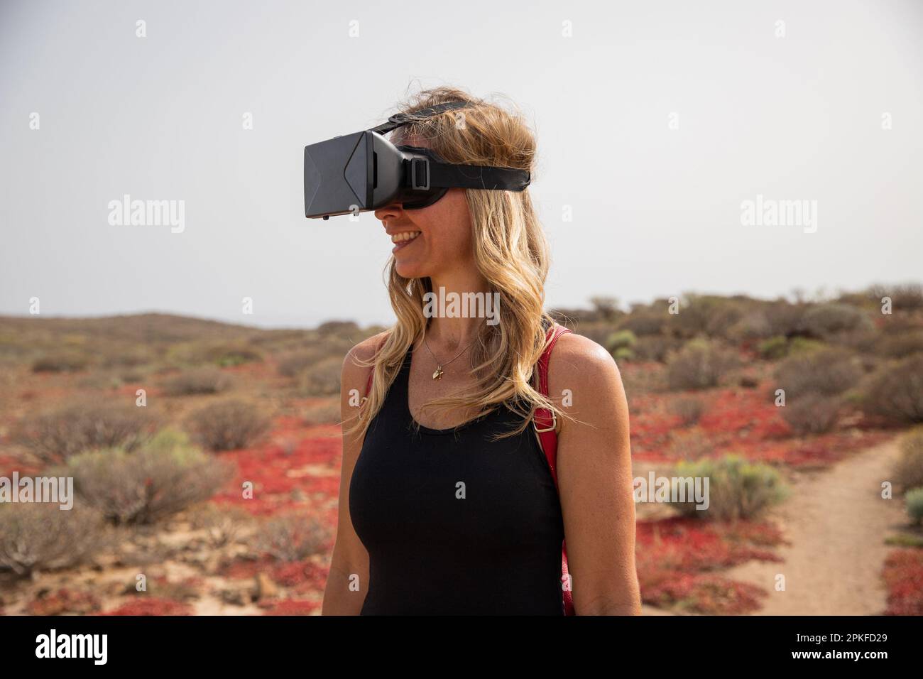 Un escursionista utilizza cuffie per la realtà virtuale durante un'escursione, il concetto di implementazione della tecnologia. Foto Stock