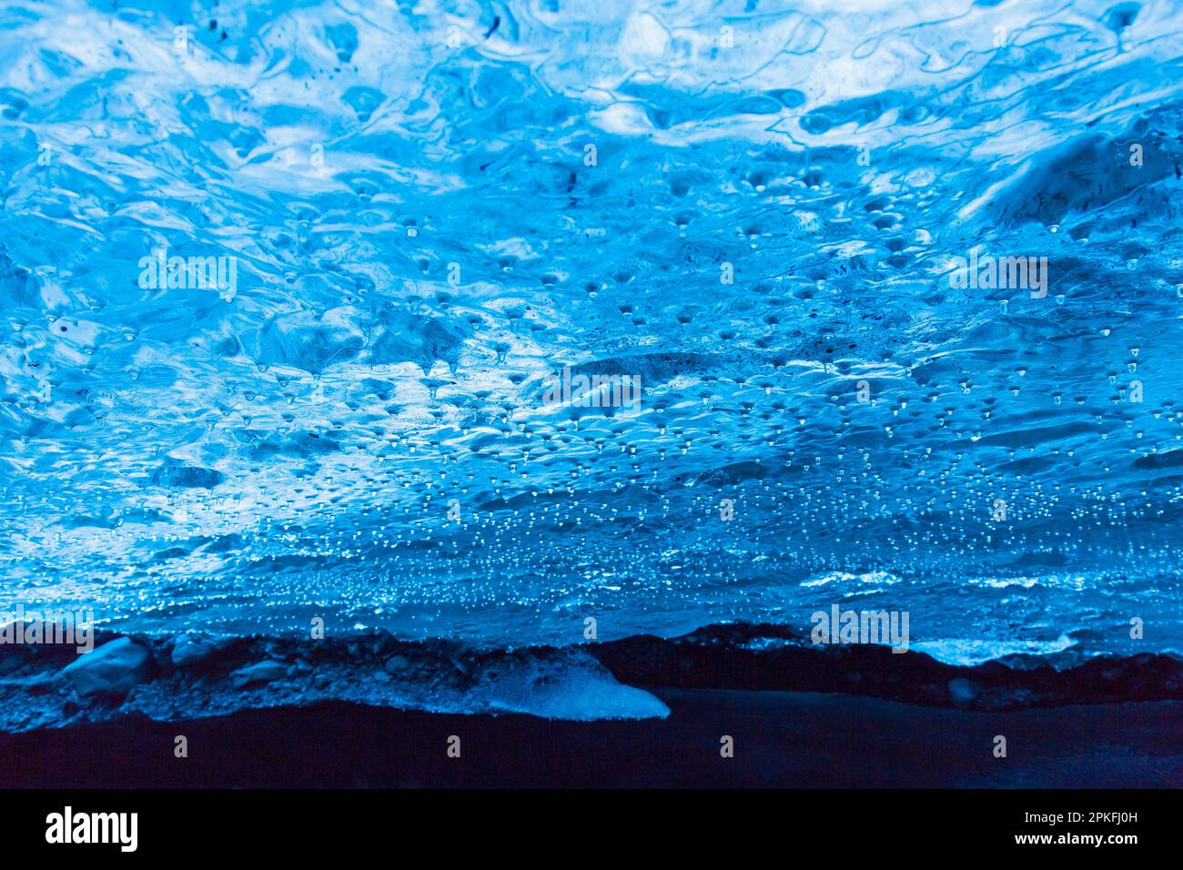 Goccioline, acqua che gocciola dal soffitto all'interno della grotta di ghiaccio naturale a Breiðamerkurjökull / ghiacciaio Breidamerkurjokull nel Parco Nazionale di Vatnajökull, Islanda Foto Stock