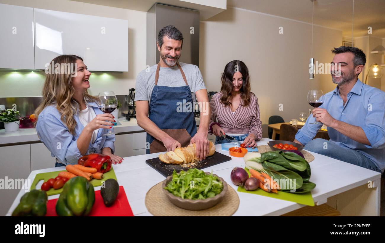 Coppia matura cenando a casa mentre si prepara una cena vegana e sana, concetto di sana alimentazione Foto Stock